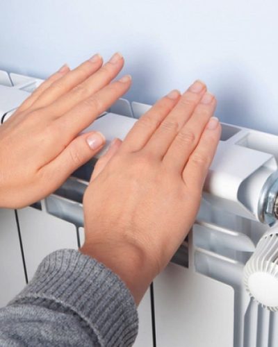 Personne se réchauffant les mains sur un radiateur